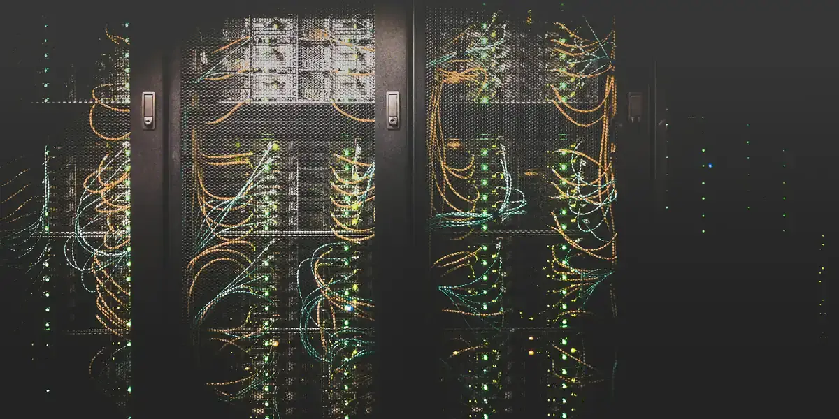 Racks de servidores iluminados en una sala de alojamiento web